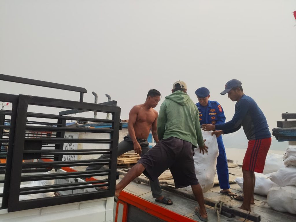 Polisi Penolong, Personel Polairud Sungai Raya Bantu ABK Bongkar Muat Kelapa Bulat dari KM. Mega