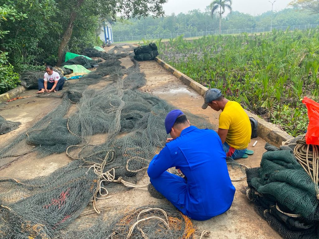 Wujud Polisi Penolong, Personel Polairud Paloh Bantu Nelayan Perbaiki Jaring Rusak di Pelabuhan Merbau